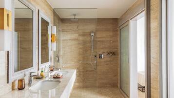 Een moderne badkamer met twee wasbakken, een grote spiegel, een douche en een glazen deur naar een balkon.
