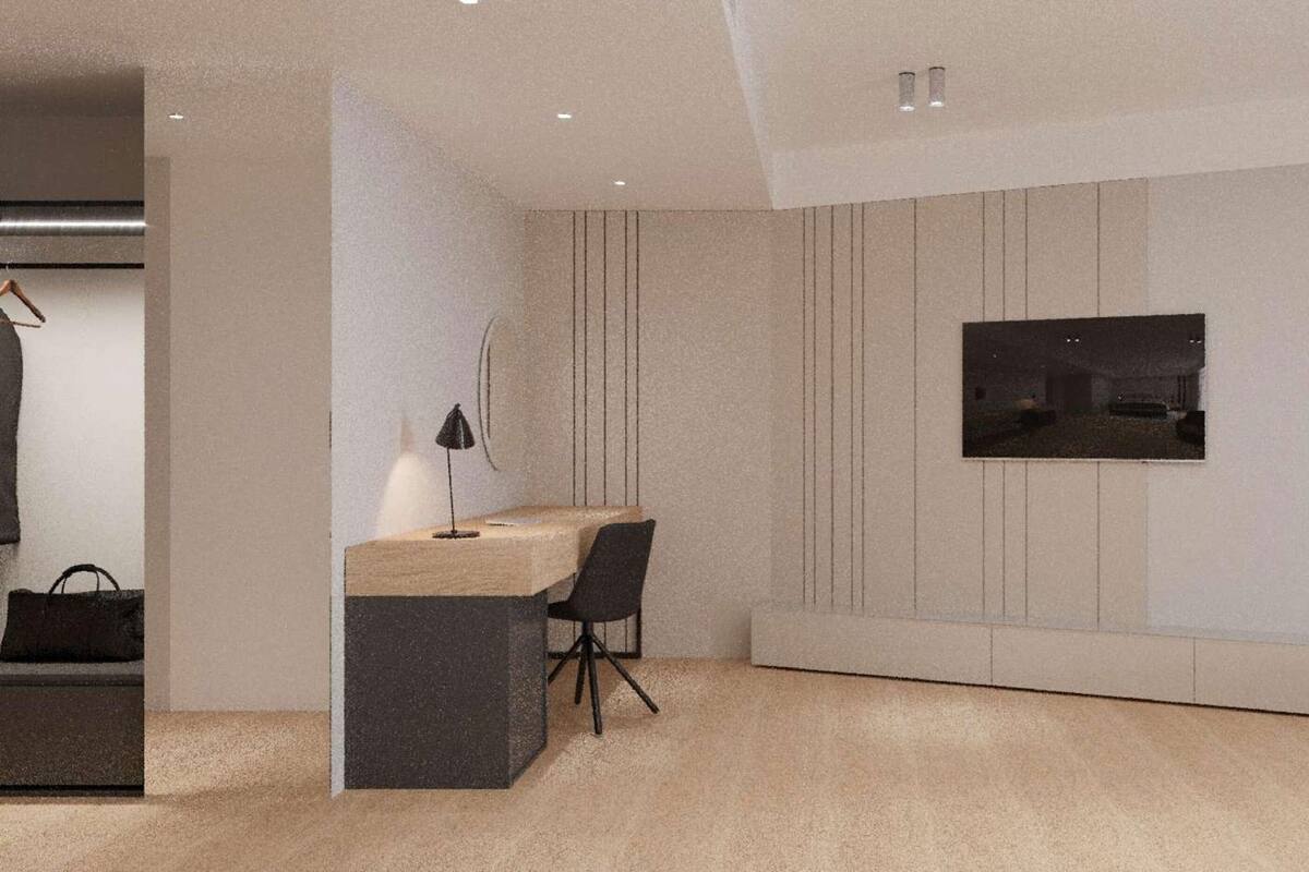 A modern room with a desk, chair, and a TV mounted on the wall.