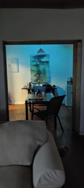Relax in this stylish space with a sofa, dining area, and artwork.