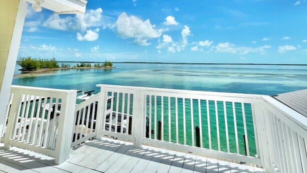 A wooden deck with a view of a clear blue sky and turquoise water. - Bimini Vacation Apartment - APT#3 (Bimini)