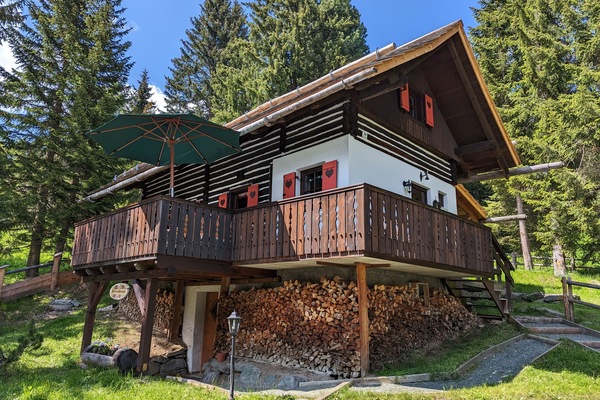 Die Sechszirbenhütte im Sommer – mit Sonnenschirm auf dem Balkon.