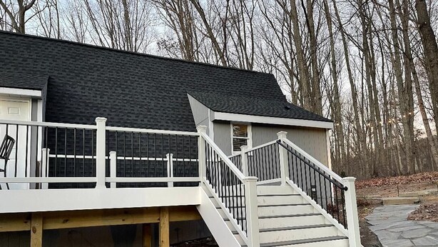 A house with a white exterior, a grey roof, and a white staircase leading to a deck. - A-Frame Mountain Retreat (Gerrardstown)