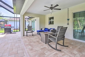A covered patio area with a ceiling fan, a barbecue grill, and outdoor furniture. - Private Heated Pool, Near Warm Mineral Springs (North Port)