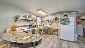 Eine kompakte Küche mit Kochinsel, integrierten Geräten und einem Kühlschrank mit Magneten.