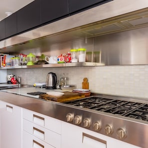 Enjoy cooking in this well-equipped kitchen with a gas range, kettle, and ample counter space.