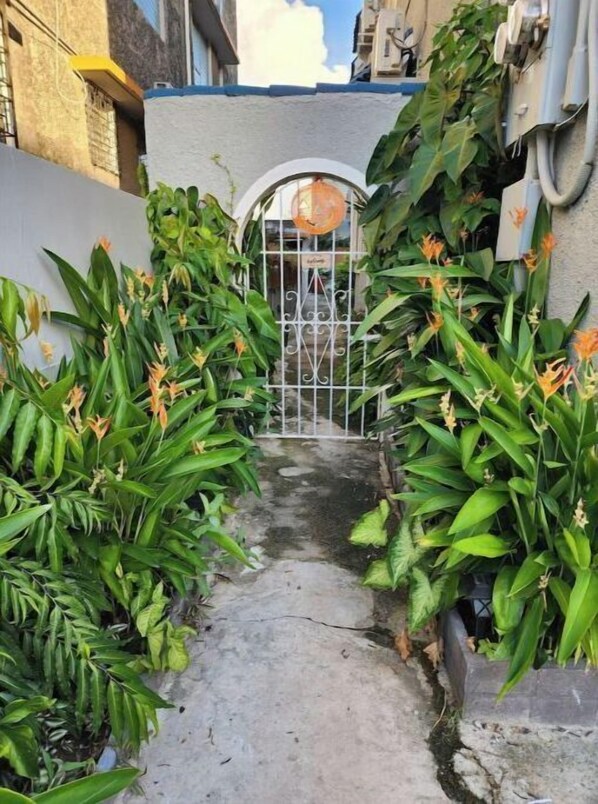 entrance to a serene and well-maintained property, surrounded by lush foliage.