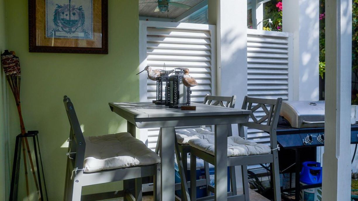 A dining area with a table, chairs, and a grill.