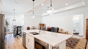 A modern kitchen with a central island, built-in oven, and a dining area with a chandelier. - home in fort payne (Fort Payne)