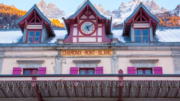 Ein Gebäude mit einer Uhr und einem Schild, auf dem "CHAMONIX - MONT - BLANC" steht.