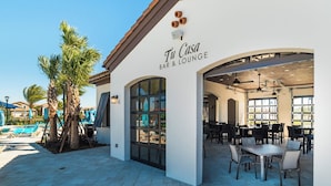 Un bar e lounge chiamato 'Tu Casa' con posti a sedere all'aperto e una zona piscina.