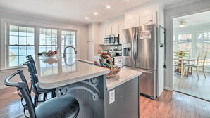 A modern kitchen with a large island, stainless steel appliances, and a view to the outside. - Country-Chic Home w/ Fire Pit, Steps to Lake! (New Concord)