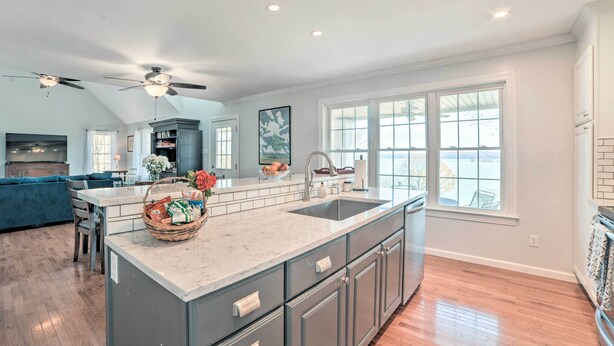 A spacious kitchen with a large island, dark gray cabinets, and a white countertop. - Country-Chic Home w/ Fire Pit, Steps to Lake! (New Concord)