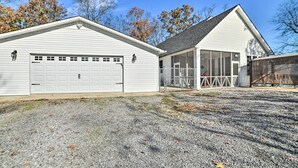 A two-story house with a garage, a covered porch, and a fenced yard. - Country-Chic Home w/ Fire Pit, Steps to Lake! (New Concord)