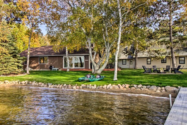 Una propiedad frente al lago con una casa, un muelle y un bote.