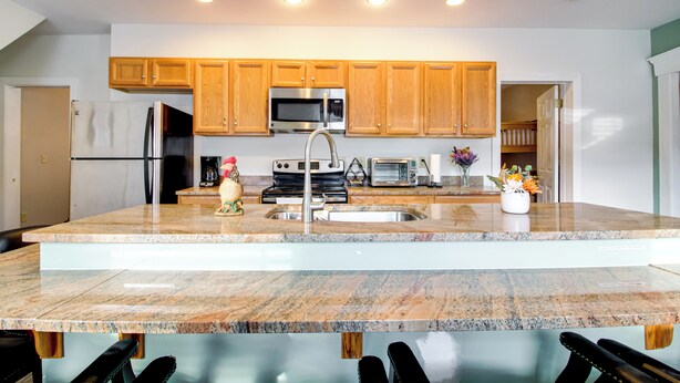 A modern kitchen with wooden cabinets, stainless steel appliances, and a granite countertop. - All-Season Ludlow Apartment: 3 Mi to Okemo Resort! (Ludlow)