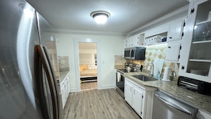 Eine Küche mit Kühlschrank, Mikrowelle, Backofen und Spüle.