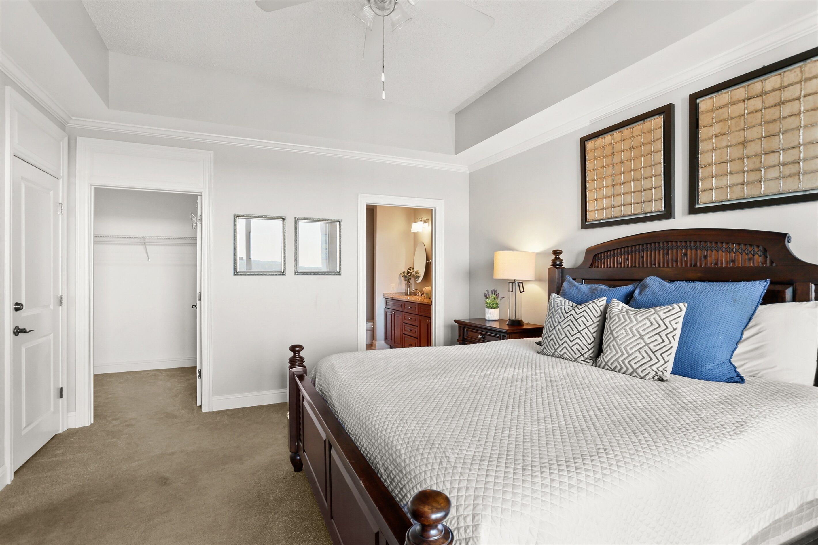 Een slaapkamer met een groot bed, een nachtkastje, een dressoir en een kast.