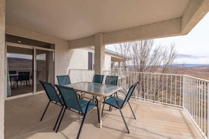 Ein Balkon mit Tisch und Stühlen, einem weißen Geländer und Blick auf die Landschaft.