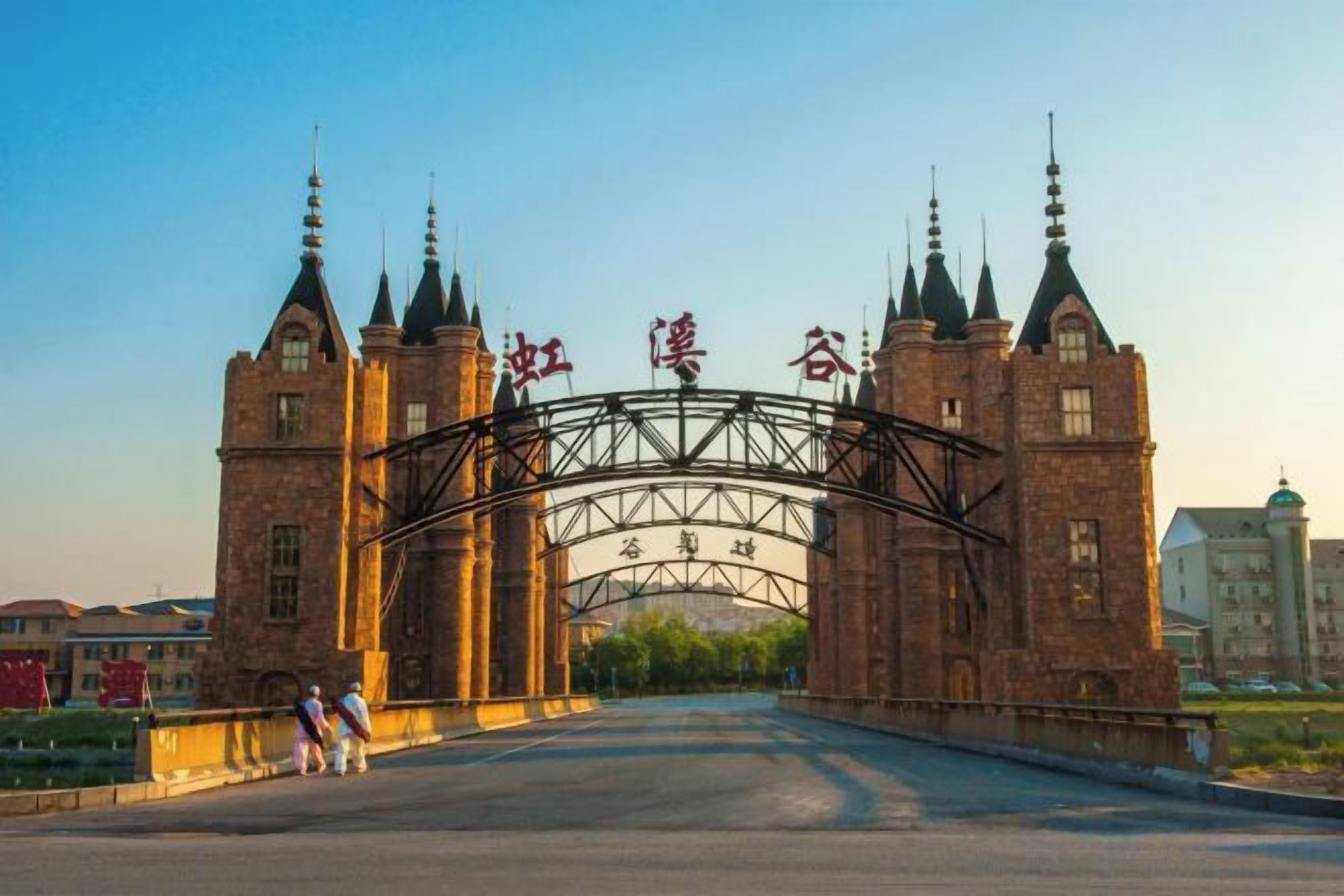 A large, historic building with a prominent archway and multiple towers.