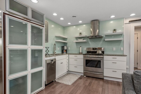 Enjoy cooking in this well-lit kitchen with a stove, microwave, and dishwasher.