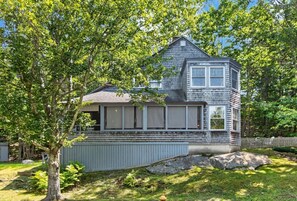A two-story house with a gabled roof, a front porch, and a fenced backyard. - Recently Renovated Home Minutes from Ocean Point (Boothbay)