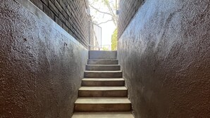 Eine schmale Betontreppe mit Metallgeländern an beiden Seiten, die nach oben führt.