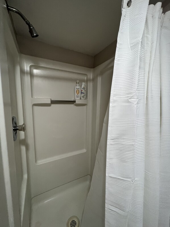 A bathroom with a shower, a toilet, and a sink.