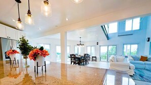 A spacious living area with a polished floor, a dining area, and a seating area with a sofa and chairs.