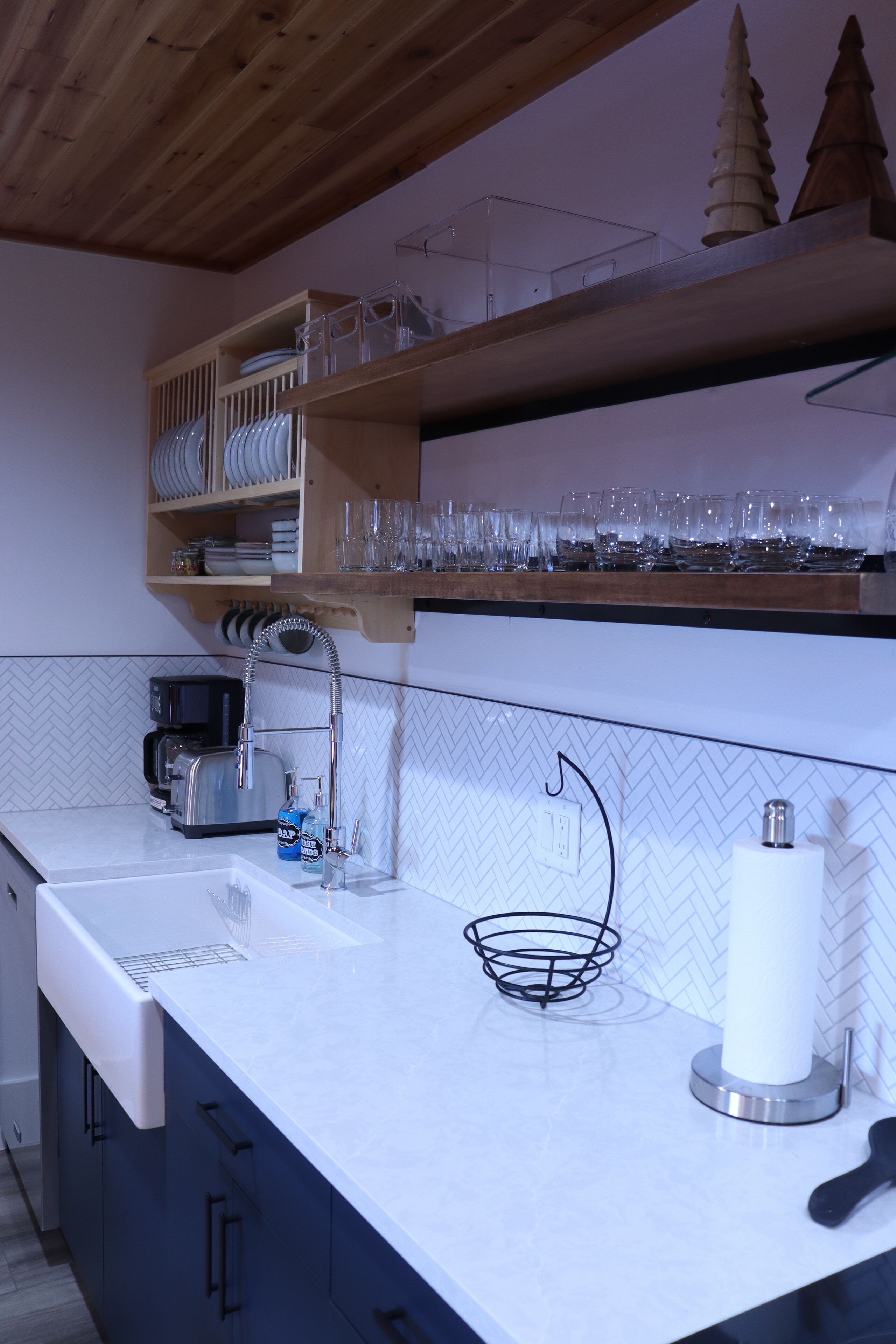 Een moderne keuken met een wit aanrecht, een koffieapparaat en een spoelbak.