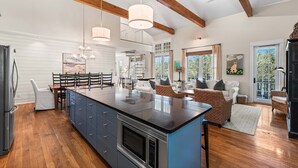 A spacious kitchen with a large island, wooden beams, and pendant lighting. - Bon Temps | 5 Bedroom w/Private Pool (Rosemary Beach)