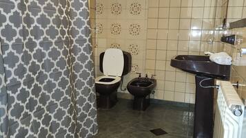 A bathroom with a toilet, bidet, and sink.
