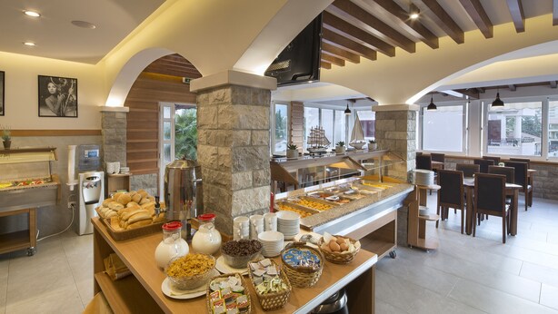 Un área de bufé con diferentes opciones de comida y un espacio de comedor con mesas y sillas.