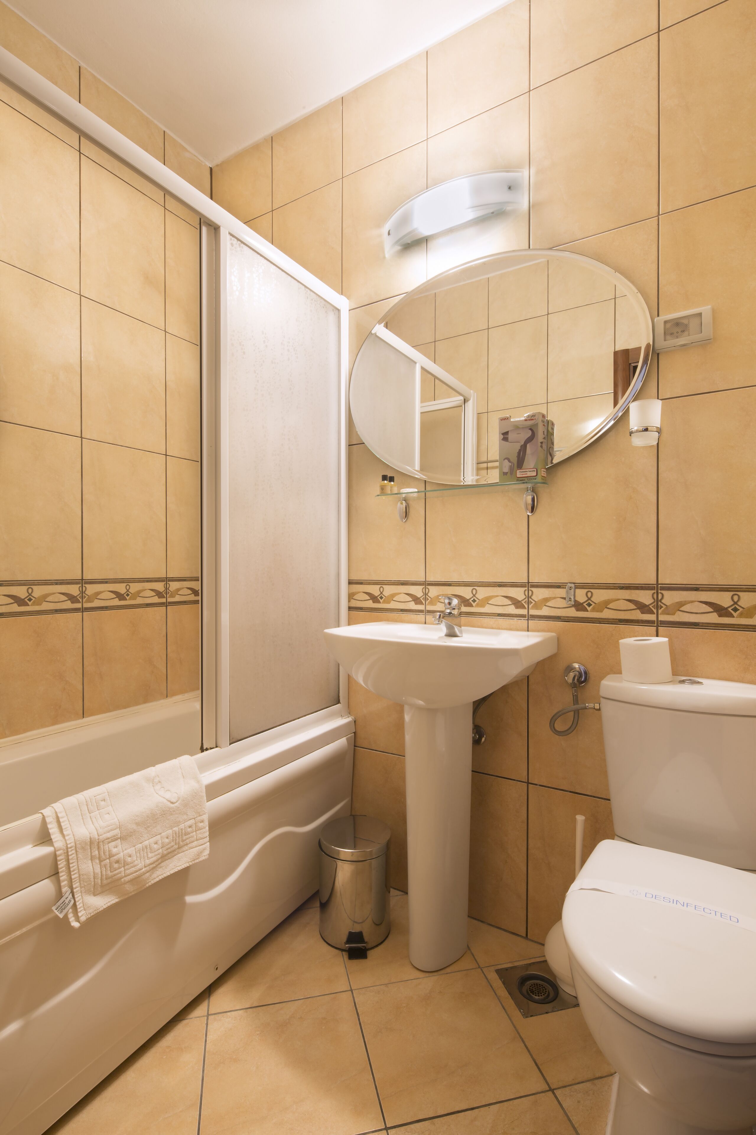Un baño con bañera, lavamanos, inodoro y espejo.