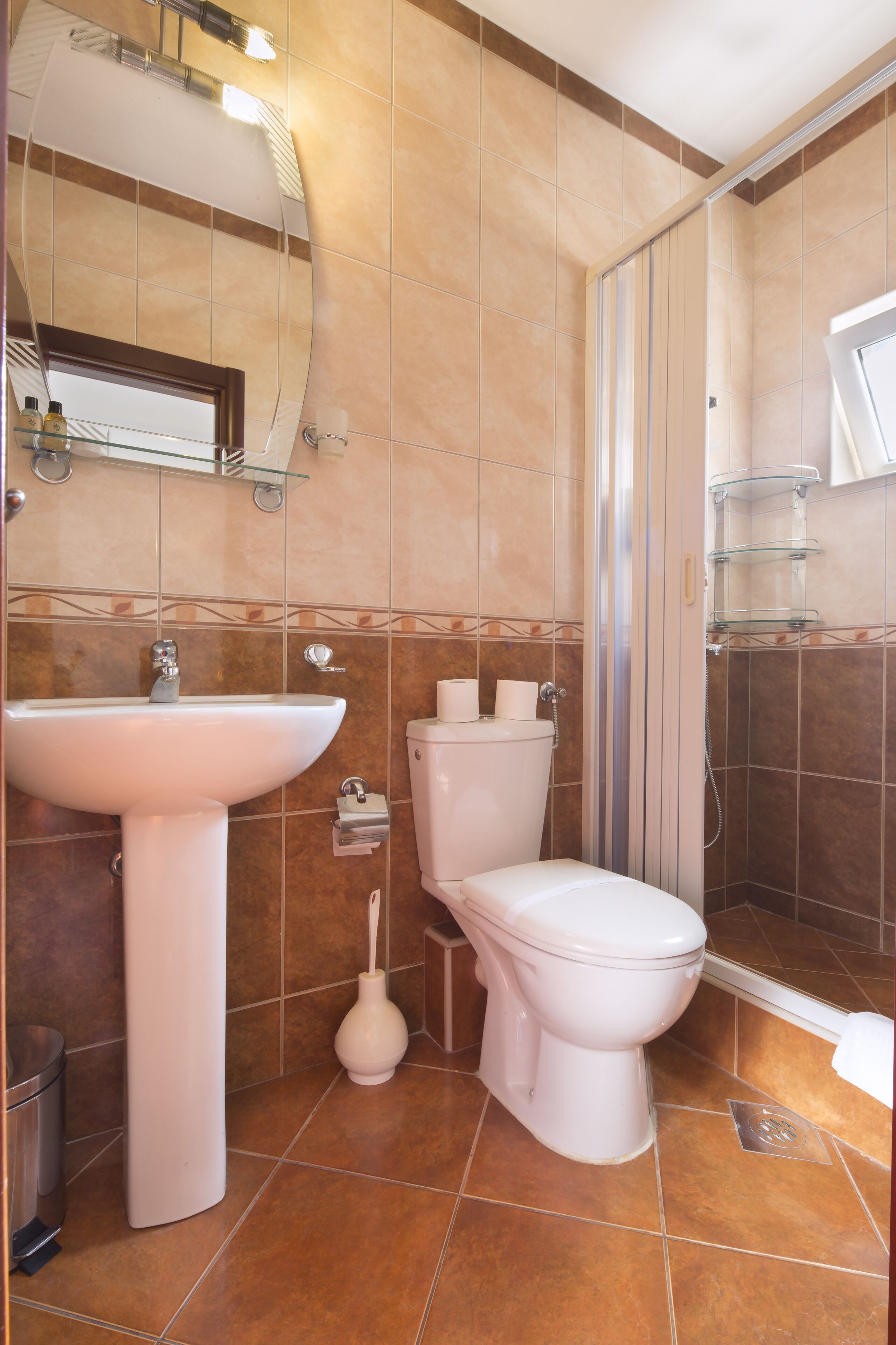 Un baño con lavamanos, inodoro y ducha.