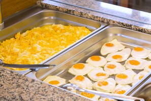 Un bufé con huevos revueltos y fritos.