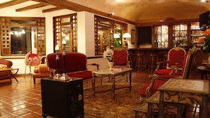 A traditional interior with wooden furniture, a tiled floor, and a bar area.