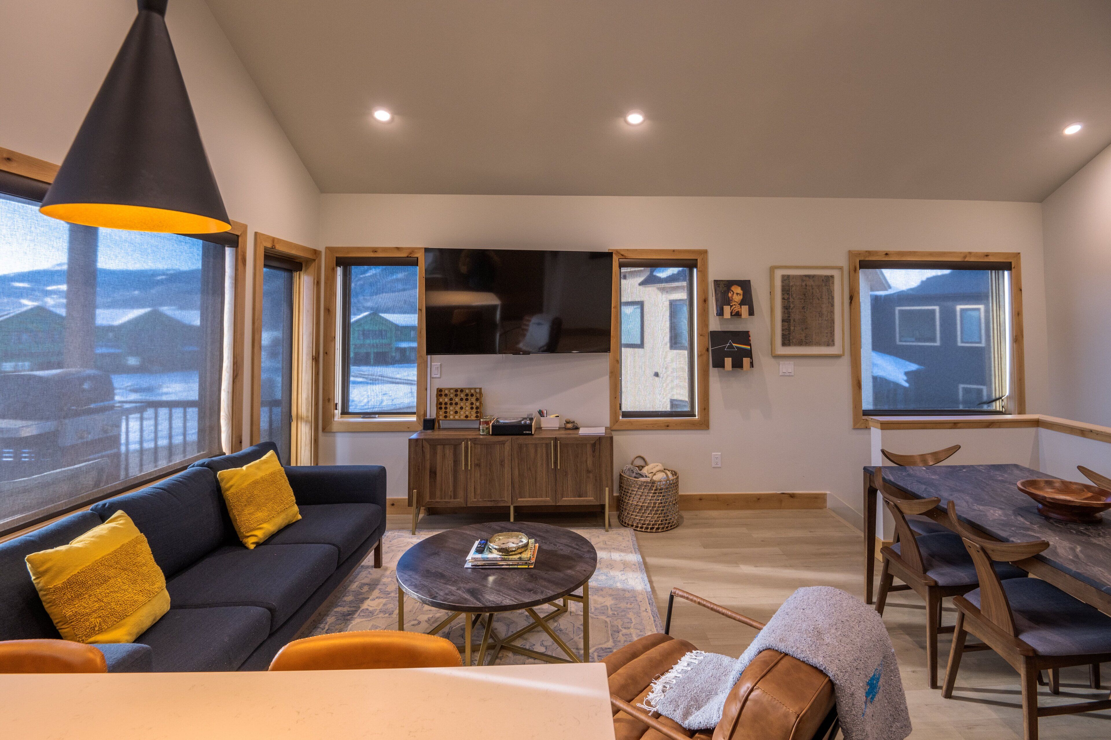 En moderne stue med sofa, sofabord og spiseplads.