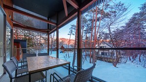 A modern interior with a large window overlooking a snowy landscape.