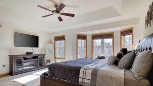 A bedroom with a bed, a ceiling fan, a TV, and a window with blinds. - Cozy Spacious Luxury Home with lots of Positivity Energy! (Tobyhanna)