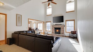 A spacious living room with a large sectional sofa, a fireplace, a flat-screen TV, and a ceiling fan. - Cozy Spacious Luxury Home with lots of Positivity Energy! (Tobyhanna)