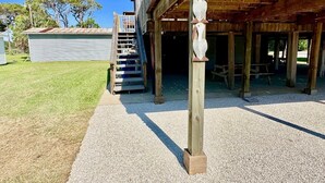 A wooden structure with a covered porch and a staircase leading to an upper level. - GENTLE BREEZE is Close to Beach in POC (Port O Connor)
