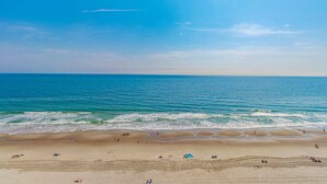 Una playa con cielos despejados y aguas tranquilas.