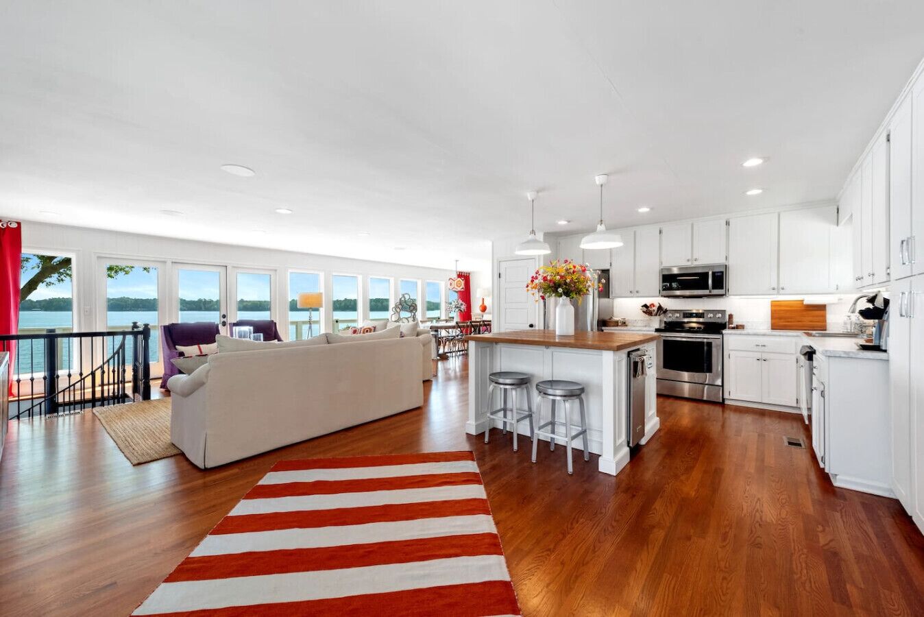 A modern kitchen with white cabinets, stainless steel appliances, and a wooden island.