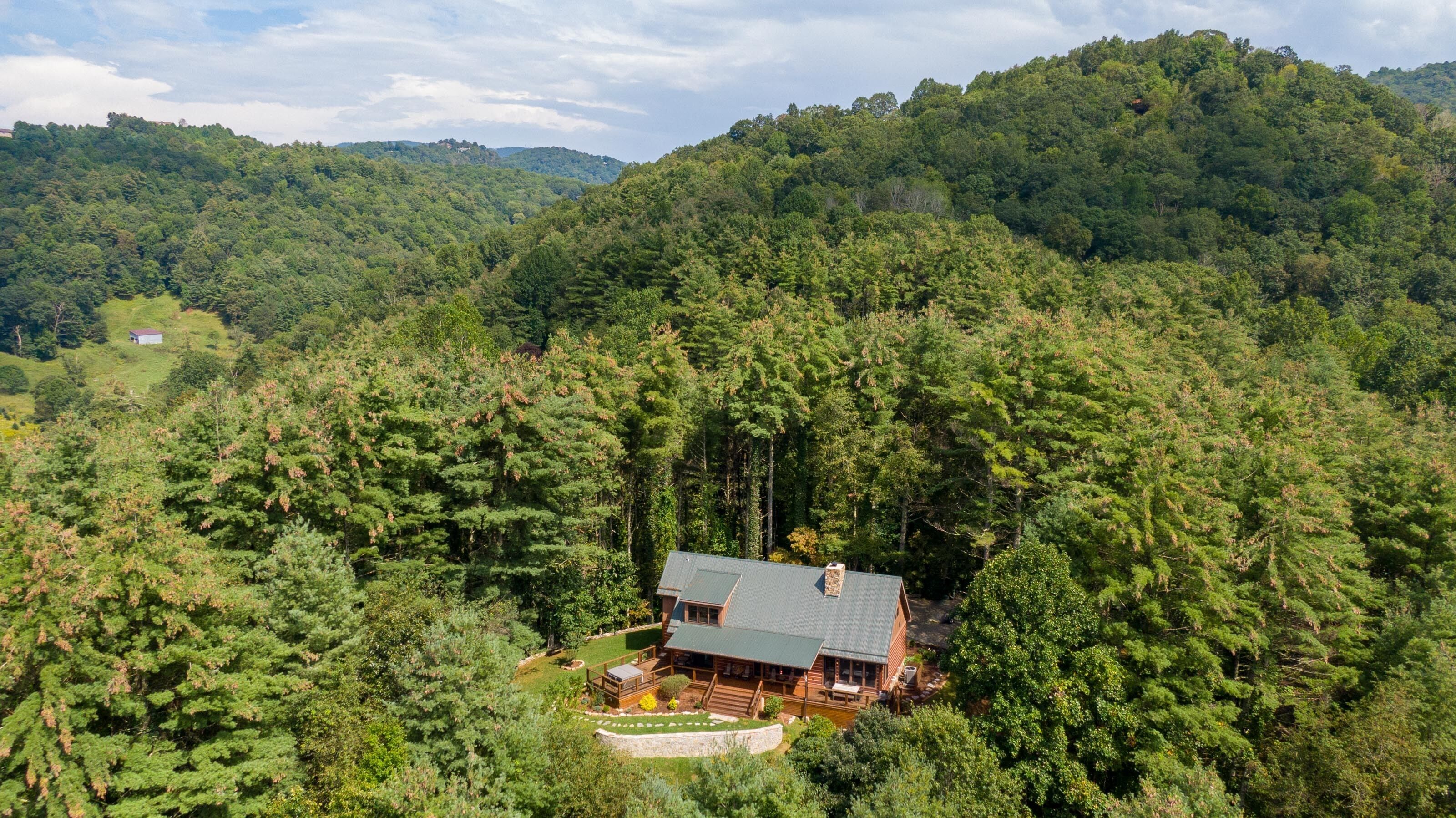 Une cabane entourée d’une forêt dense, offrant une vue dégagée sur les collines environnantes.