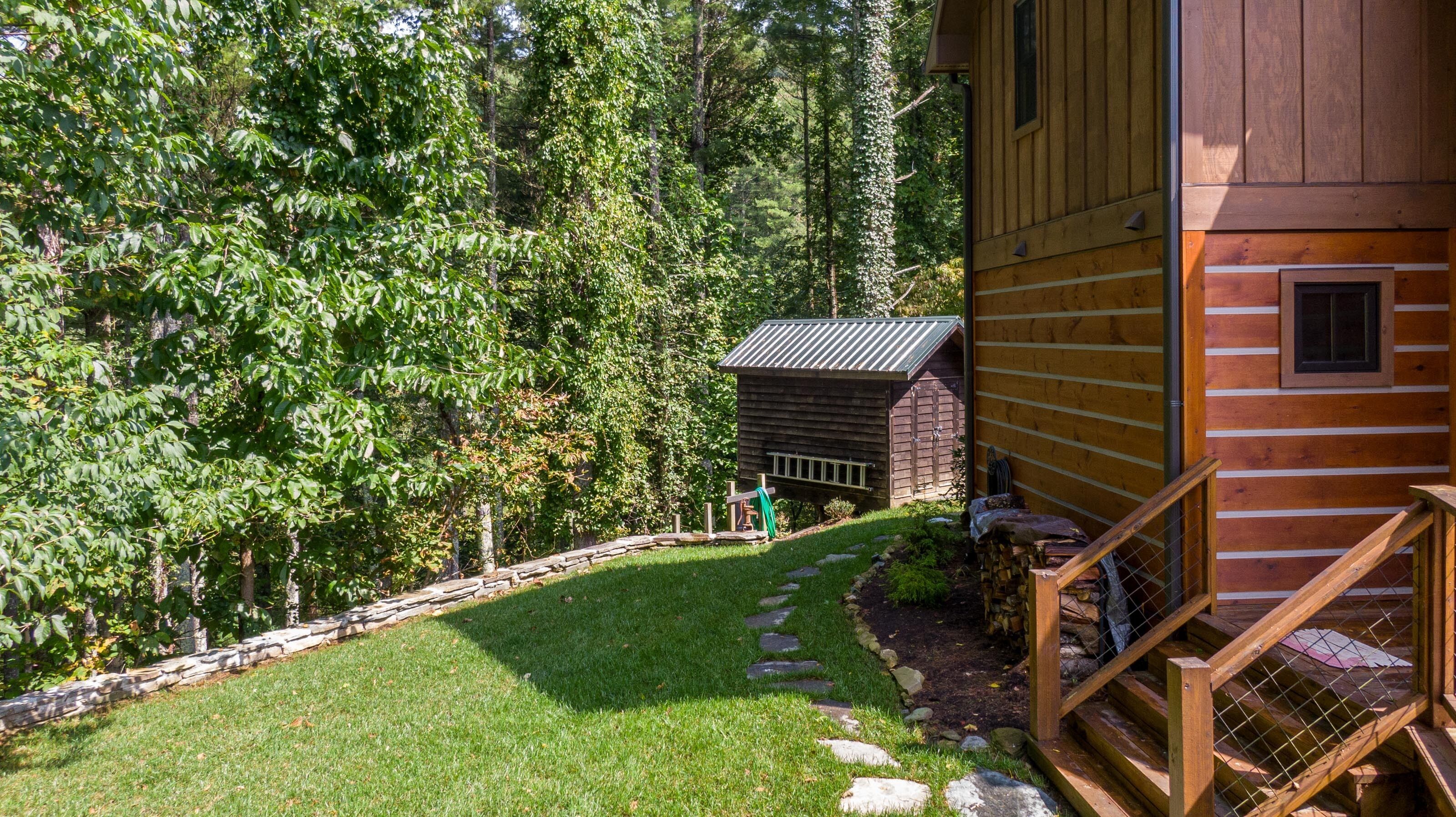 A wooden cabin with a stone pathway leading to a wooden deck.