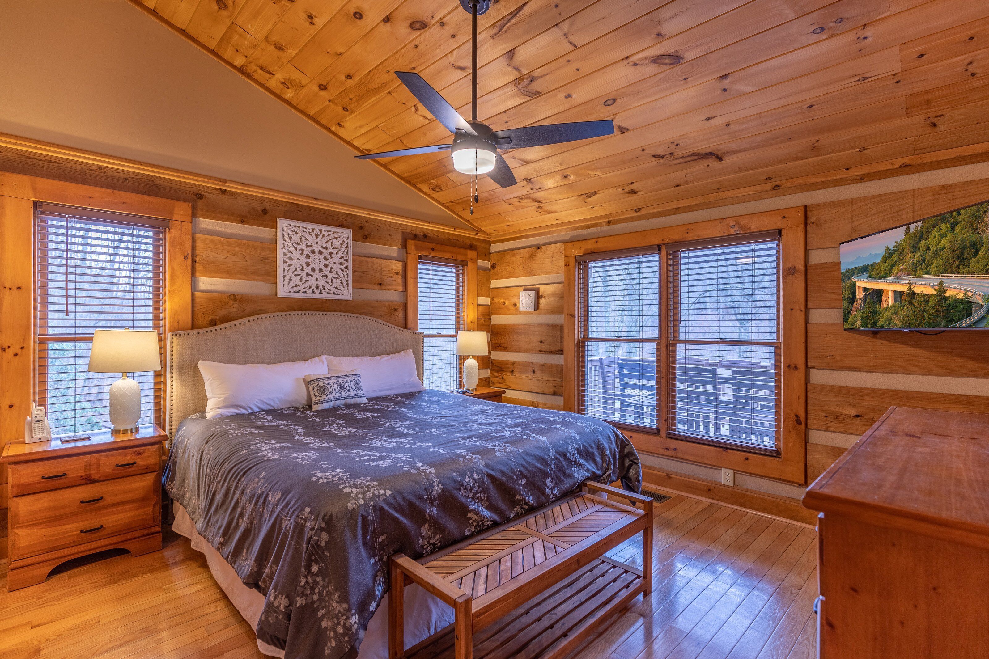 Rest easy in this king bedroom wrapped in warm log cabin wood, with bright windows and a flat-screen TV to unwind after a Blue Ridge adventure.