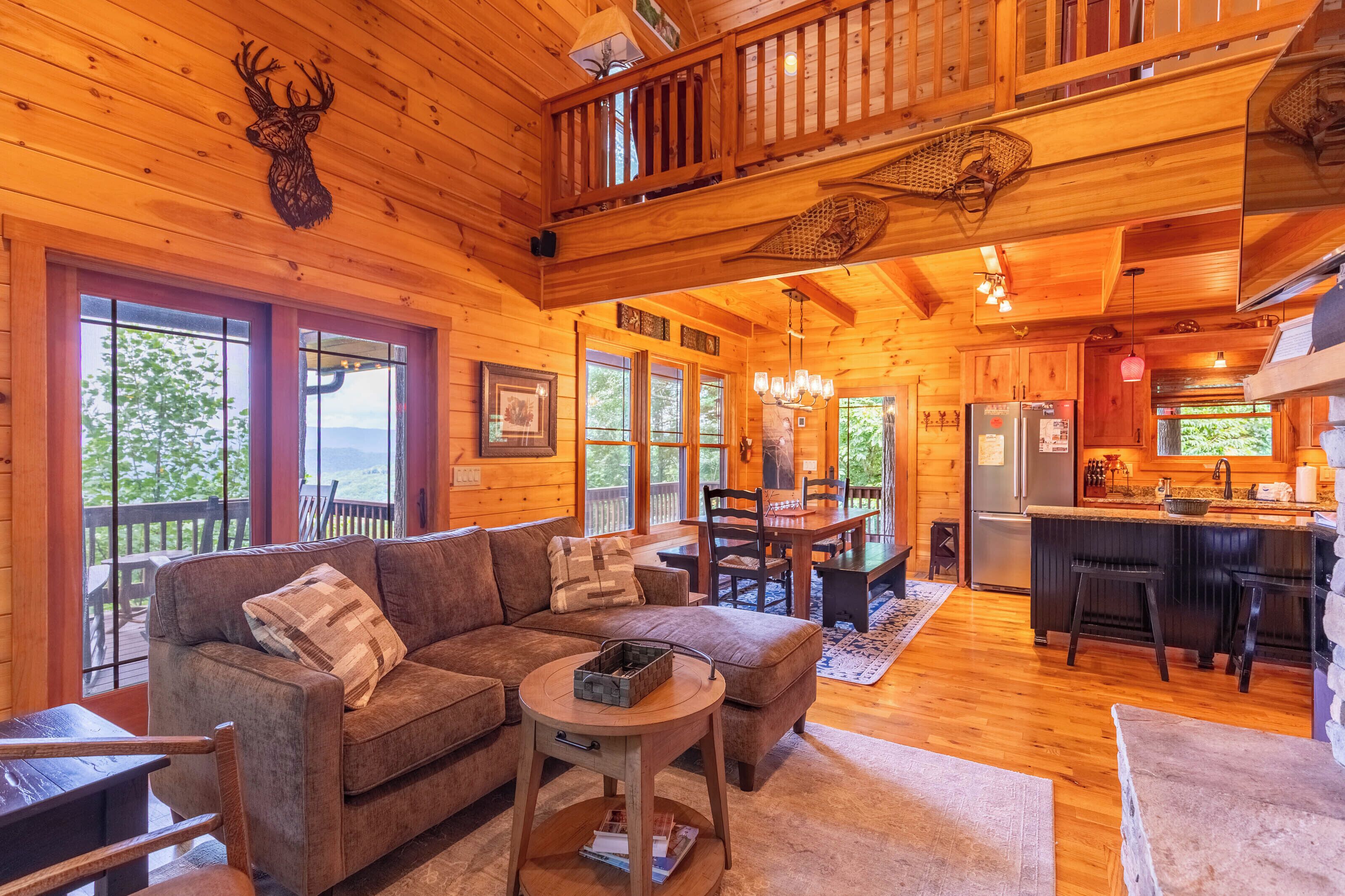 L’intérieur d’un chalet en bois comprend un salon, un coin repas, une cuisine et un balcon avec vue.