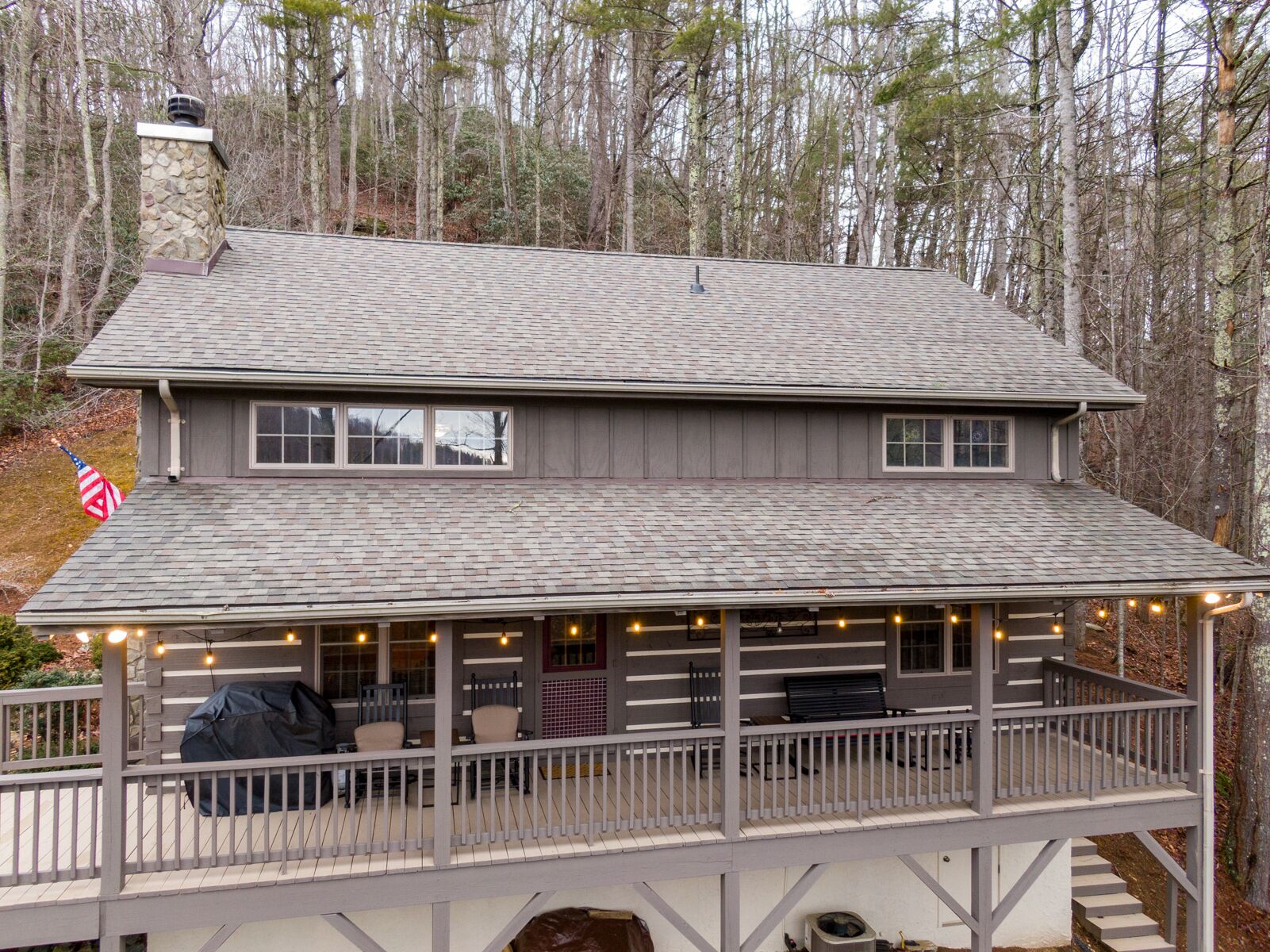 A two-story house with a covered porch and a chimney.