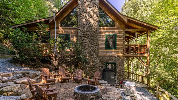 A rustic cabin with a stone chimney, wooden deck, and Adirondack chairs. - Skylark - Cozy Log Cabin with 3 bedrooms, 3 baths, and hot tub (Banner Elk)