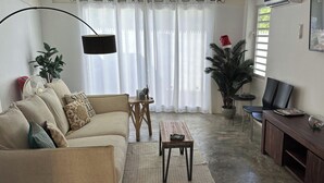 Un salon avec un canapé, une table basse et un meuble pour la télévision.